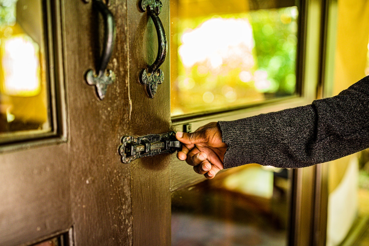 Woman closing the door with a door lock installed on a wooden door